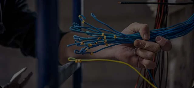 Electrical conductors with exposed ends in a technician’s hands